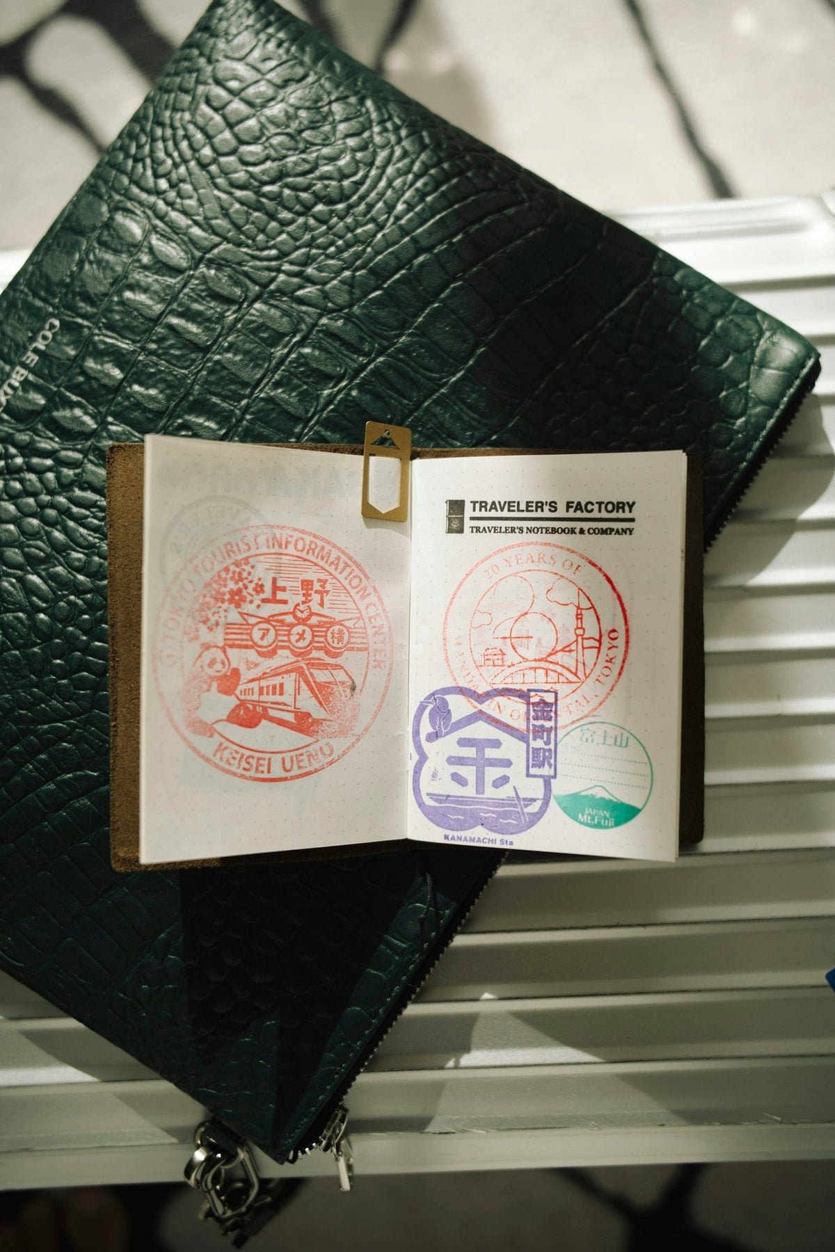 Open passport with colourful travel stamps next to travel accessories