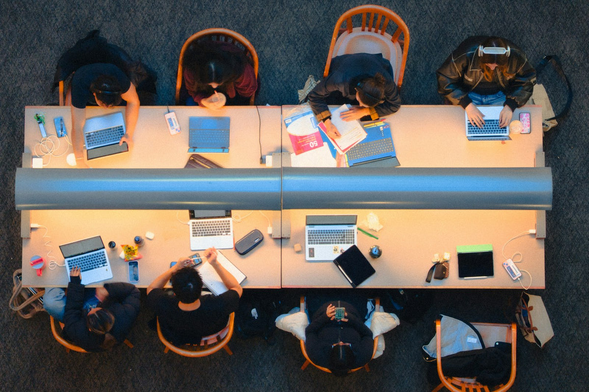 Students studying together at a long table in a library